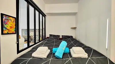 a bedroom with a bed with two blue pillows at Alex Nice Studio in Nice