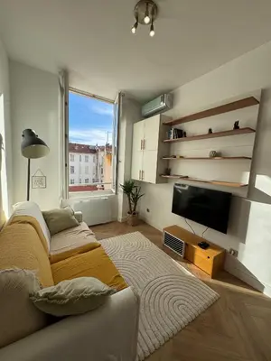 a living room with a couch and a flat screen tv at Cosy Cocoon Place Massena in Nice