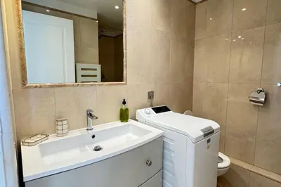 a bathroom with a sink and a toilet and a mirror at Cosy Cocoon Place Massena in Nice