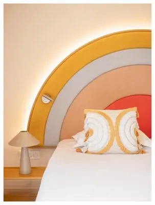 a bed with a large wooden headboard with a pillow at Nice Pam Hotel in Nice