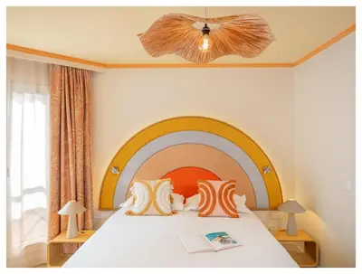 a bedroom with a large bed with a rainbow headboard at Nice Pam Hotel in Nice