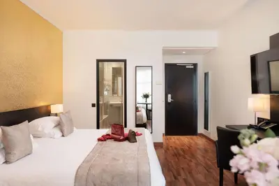a hotel room with a bed with a red purse on it at Best Western Plus Hôtel Massena Nice in Nice