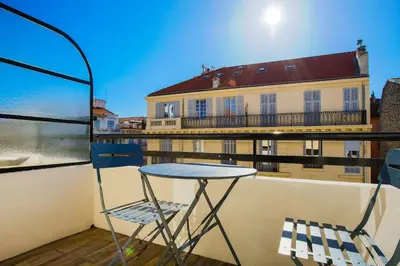 a table and chairs on a balcony with a building at Rossini Centre Ville - Proche Tram in Nice