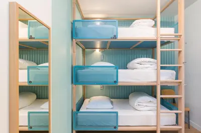 a room with bunk beds with blue shelves at Hostel Ozz Nice in Nice
