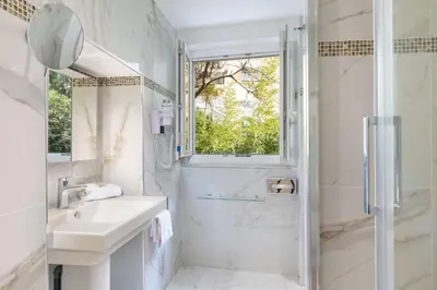 a white bathroom with a sink and a shower at Best Western Plus Hôtel Brice Garden Nice in Nice