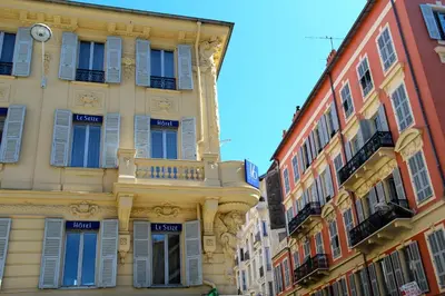 a tall building with blue shutters on it at Hôtel Le Seize, Nice Centre in Nice