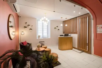 an office lobby with a reception desk and a table at Hôtel Le Seize, Nice Centre in Nice