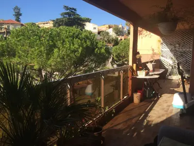 a balcony of a house with a tree on it at AZURELLE in Nice