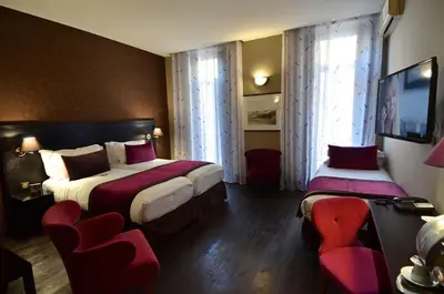 a hotel room with two beds and two chairs at Best Western Plus Nice Cosy Hotel in Nice