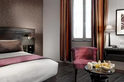 a hotel room with a bed and a chair and a table at Best Western Plus Nice Cosy Hotel in Nice