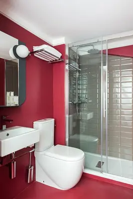 a bathroom with a toilet and a glass shower at Hôtel les Cigales in Nice