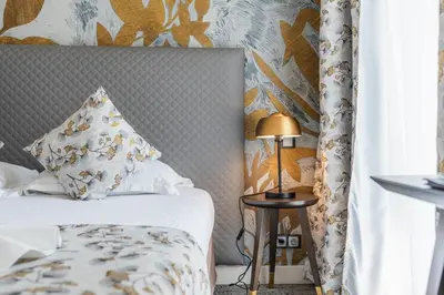a bedroom with a bed and a lamp on a table at Hotel Villa Victoria in Nice