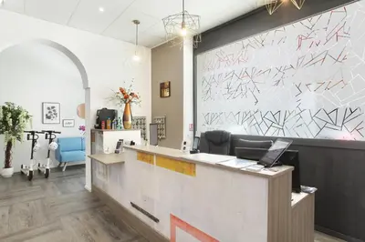 a reception area of a salon with a wall with graffiti at Hôtel Alcôve Nice in Nice