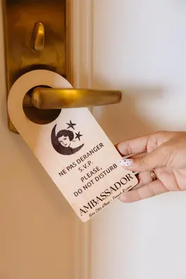 a person holding a piece of paper on a door at Hotel Ambassador, completely renovated in Nice