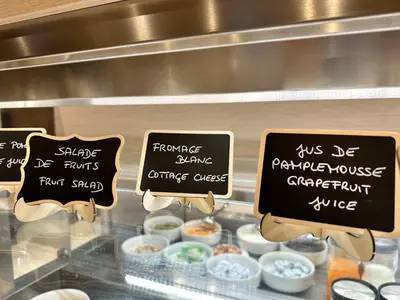 a display case with signs in front of some food at Hotel Ambassador, completely renovated in Nice
