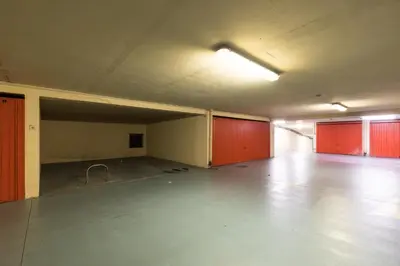 an empty parking garage with red doors and a large room at 2 Bdrs & Parking in the Old Town ! in Nice