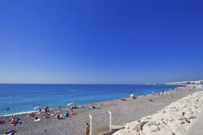 a group of people on a beach near the water at LES MOUETTES - PROMENADE HOLIDAY in Nice