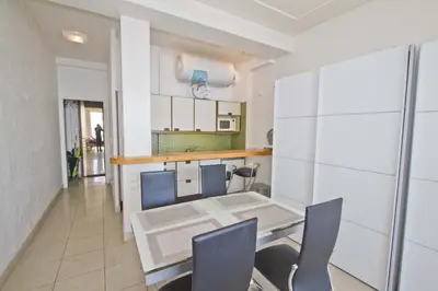 a kitchen with a table and chairs in a room at LES MOUETTES - PROMENADE HOLIDAY in Nice