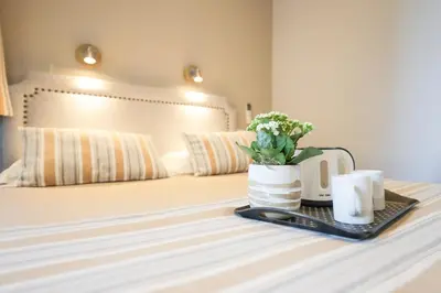 a hotel room with a bed with a laptop and flowers at Hotel Lepante in Nice