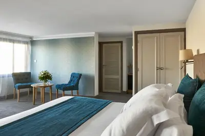 a bedroom with a bed and two chairs and a table at Splendid Hotel & Spa Nice in Nice