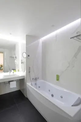 a white bathroom with a tub and a sink at Splendid Hotel & Spa Nice in Nice