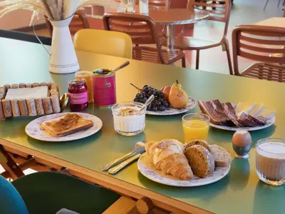 a table with plates of breakfast food on it at Greet Hotel Nice Aéroport Promenade des Anglais in Nice