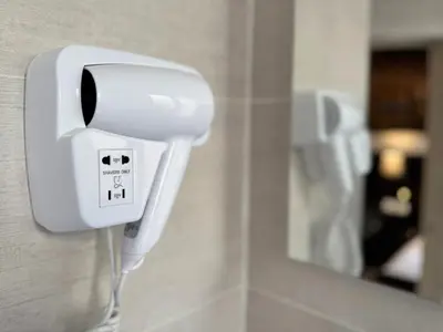 a white soap dispenser on a wall in a bathroom at Trocadero in Nice