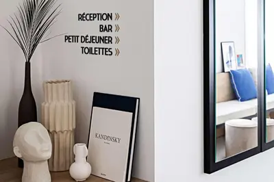 a table with two books on it next to a window at Le Riviera Collection, Signature Collection by Best Western in Nice