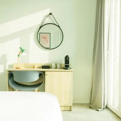 a bedroom with a mirror and a desk at Hotel Aria in Nice