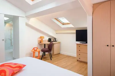 a bedroom with a bed and a desk with a television at Best Western Hotel Lakmi Nice in Nice