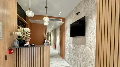 a lobby with a reception desk and a television on a wall at Hôtel Helvétique in Nice