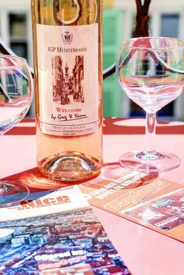 a bottle of wine sitting on a table with two glasses at Le Philibert - SPLENDID, 6 BEDROOMS, 12P, NICE PORT, Air Cond in Nice