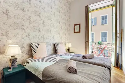 two beds in a room with a window at Le Philibert - SPLENDID, 6 BEDROOMS, 12P, NICE PORT, Air Cond in Nice