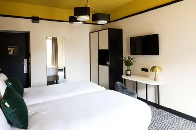 a bedroom with a large white bed and a tv at Best Western Premier Hotel Roosevelt in Nice