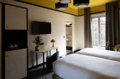 a hotel room with two beds and a desk at Best Western Premier Hotel Roosevelt in Nice