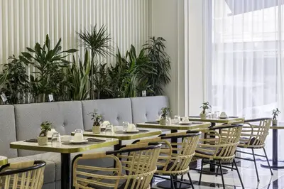 a dining room with tables and chairs and plants at Best Western Premier Hotel Roosevelt in Nice