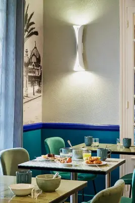 a dining room with tables and chairs and a light at Nice Excelsior Centre ville by HappyCulture in Nice