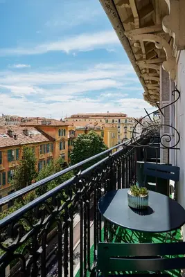 a table on a balcony with a view of a city at Nice Excelsior Centre ville by HappyCulture in Nice