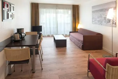 a living room with a couch and a table at Aparthotel Adagio Nice Promenade des Anglais in Nice
