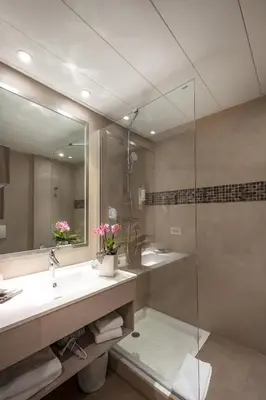a bathroom with a sink and a glass shower at Servotel Saint-Vincent in Nice