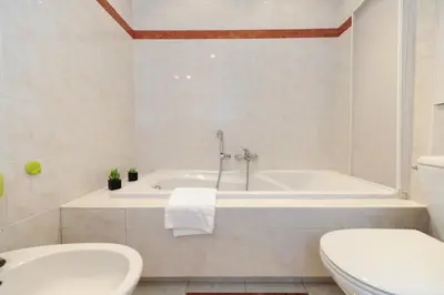 a bathroom with a tub and a toilet and a sink at Le Savoy Palace - Five Stars Holiday House in Nice