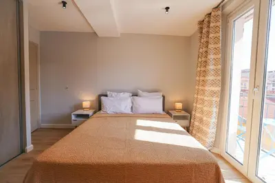 a bedroom with a large bed and a large window at AzurAppart Brilliant 2room, Nice Massena in Nice