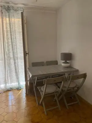 a dining room table with two chairs and a lamp at Studio in the center of Saint-Jean-cap-Ferrat in Saint-Jean-Cap-Ferrat