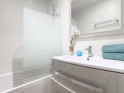 a white bathroom with a sink and a shower at Apartment Le Mozart by Interhome in Nice