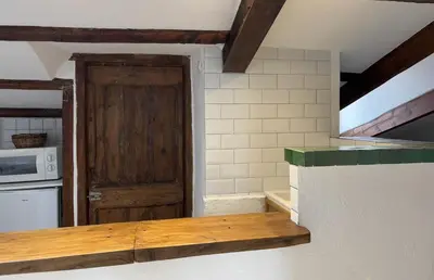a kitchen with a wooden counter and a door at Garibaldi mansardé in Nice
