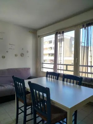 a living room with a table and chairs and a couch at Appartement F2 à 50 m de la plage in Nice