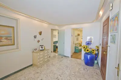 a living room with a vase with flowers in it at PROMENADE HOLIDAY - SEA FRONT PALATIN in Nice
