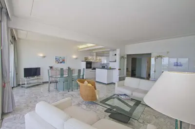 a living room with white furniture and a kitchen at PROMENADE HOLIDAY - SEA FRONT PALATIN in Nice