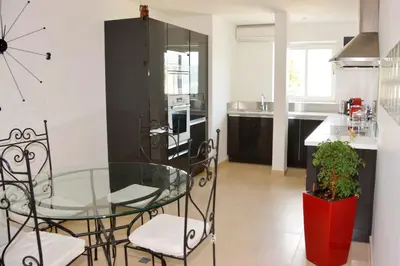 a kitchen with a glass table and some chairs at Villa ZEN in Saint-Laurent-du-Var