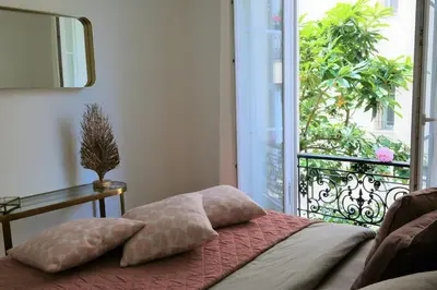 a bedroom with a bed with a view of a balcony at Nice Apartment Roses & Ivy, Rue du Congres in Nice